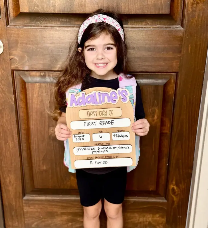 Personalized first day of school dry erase sign held up for a doorstep photo